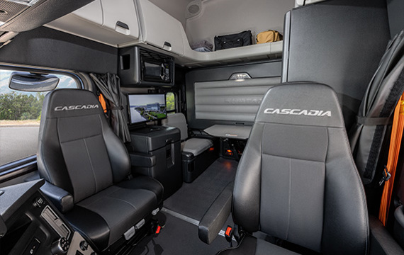 Freightliner Cascadia sleeper cab interior showing dual branded seats and living space amenities